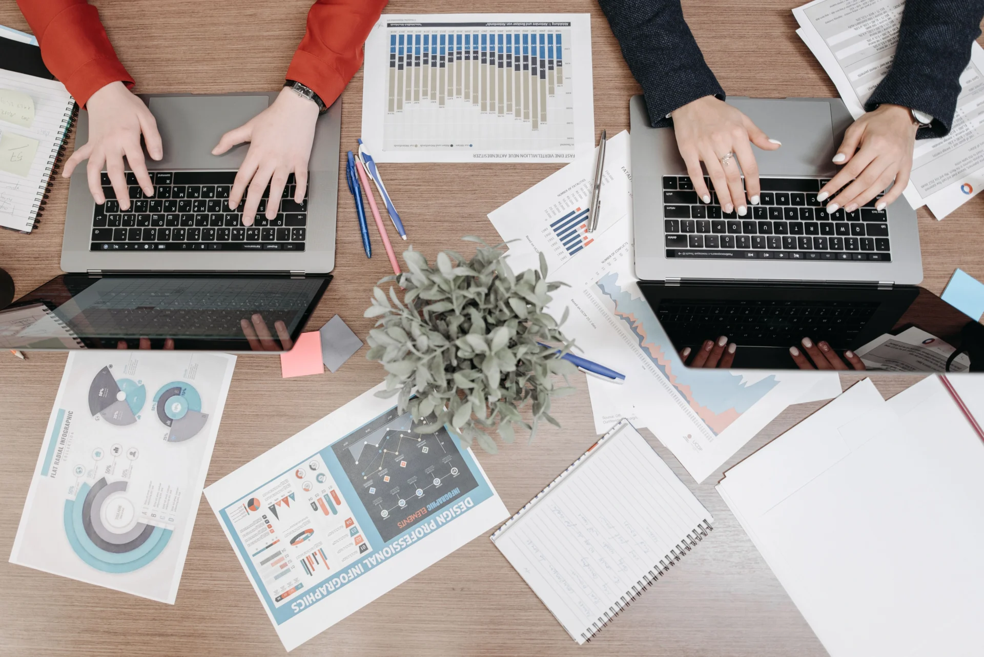 Marketing professionals working on laptops surrounded by data reports to optimize content for Google AI overviews