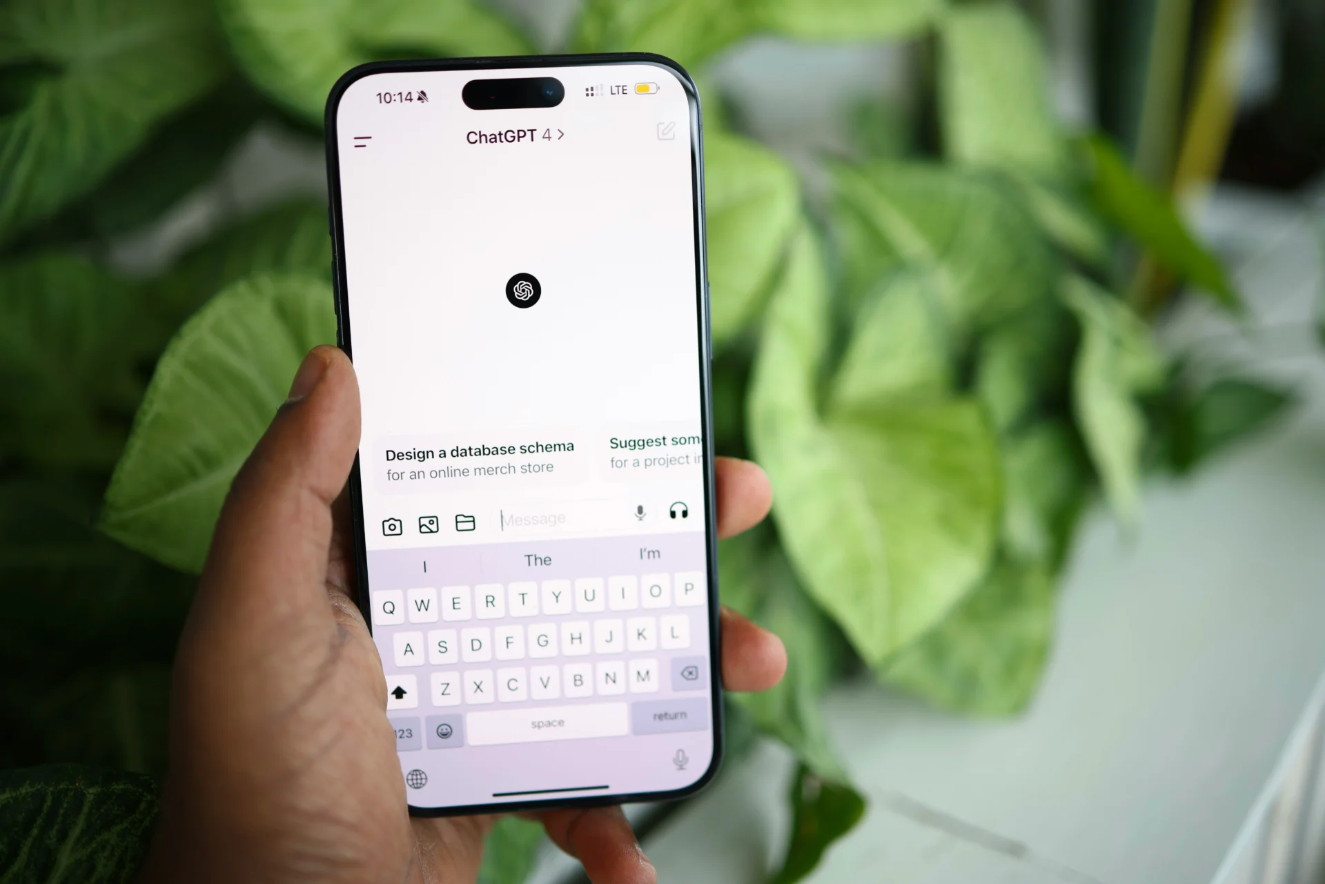 Person typing a prompt into the ChatGPT mobile app, illustrating how to appear in ChatGPT results.