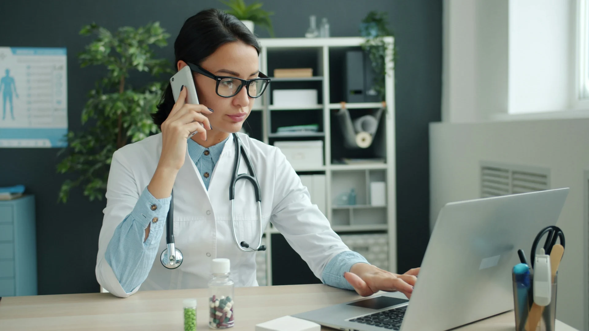 Doctor consulting a patient by phone while researching online, reflecting the value of GEO for healthcare websites.