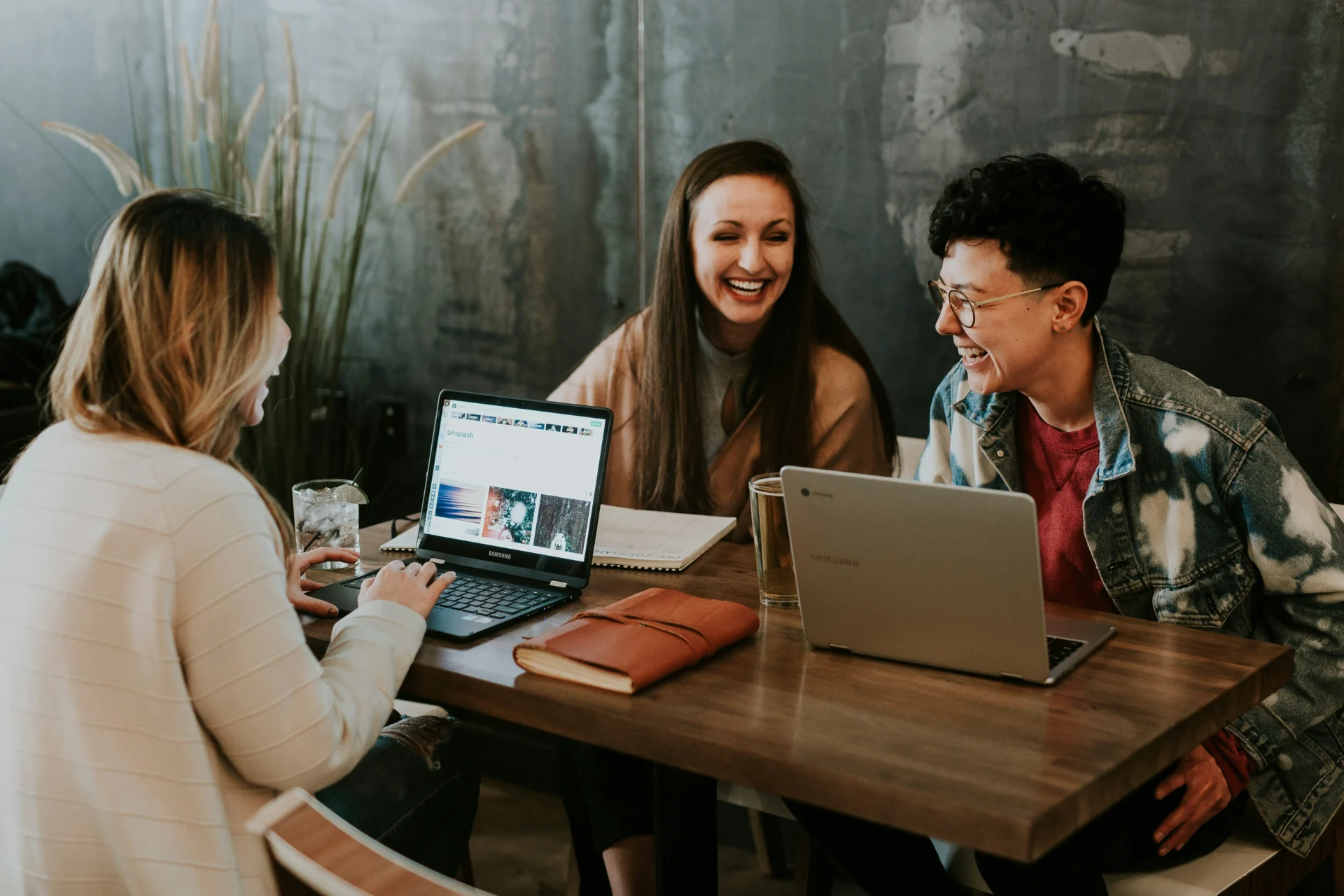 Friends collaborating on laptops learning how to plan content around AI search behaviors