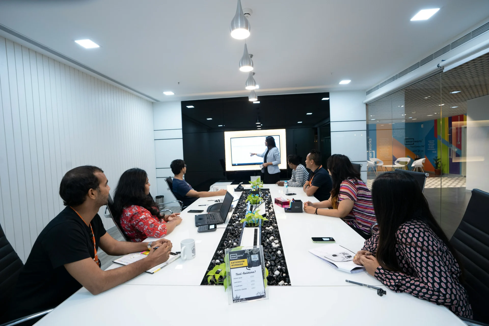 Team members attending a presentation around a conference table in a modern office