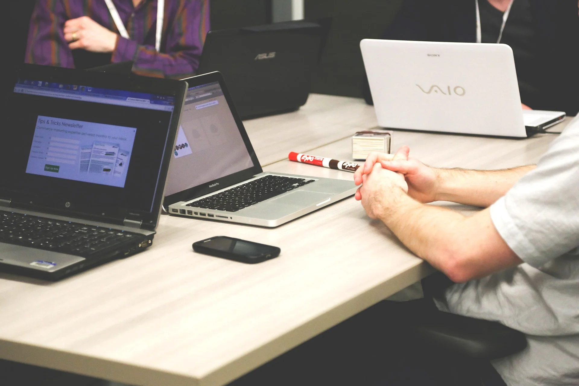 Team meeting with multiple laptops used to plan a GEO strategy for B2B